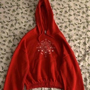 Cropped small red hoodie with drawstrings.